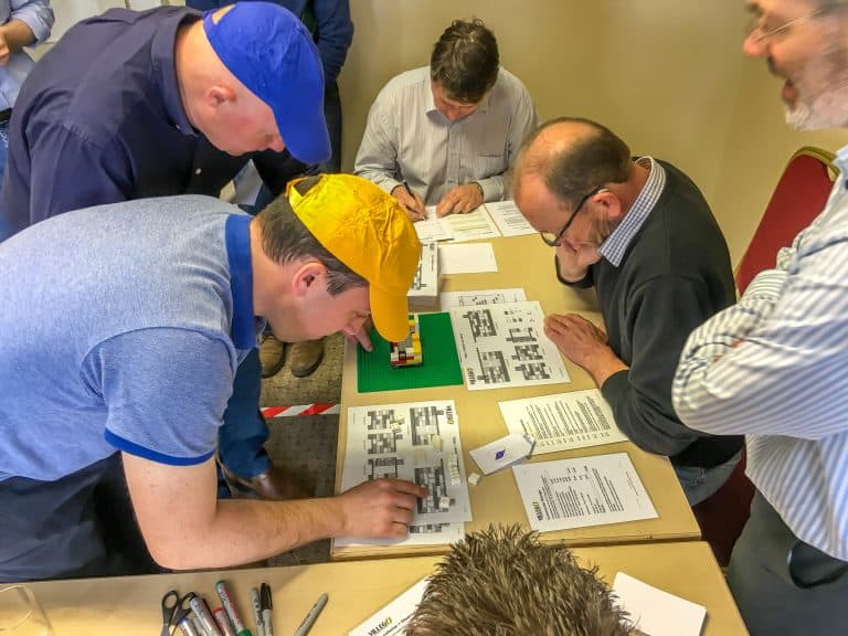 Group of professionals engaging in Lean problem-solving training session.