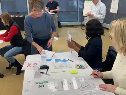 Participants engaged in a Lean training workshop in a modern office setting.