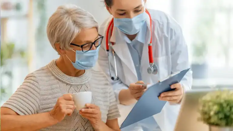 Doctor and nurse reviewing patient information with a senior woman.