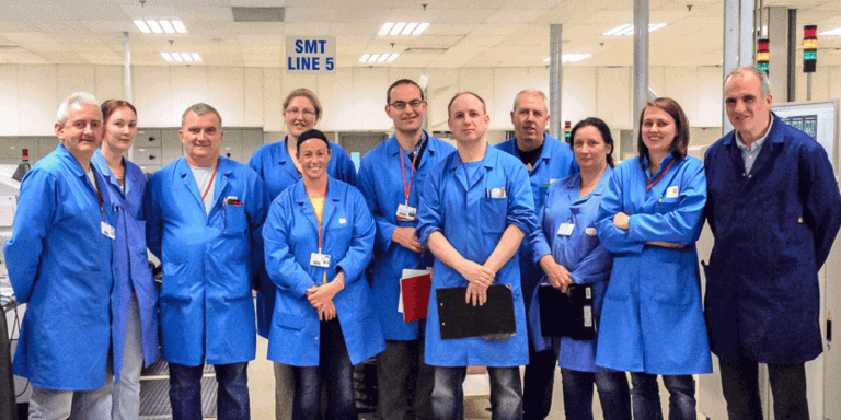 Team of professionals in blue lab coats at Lean Start event.