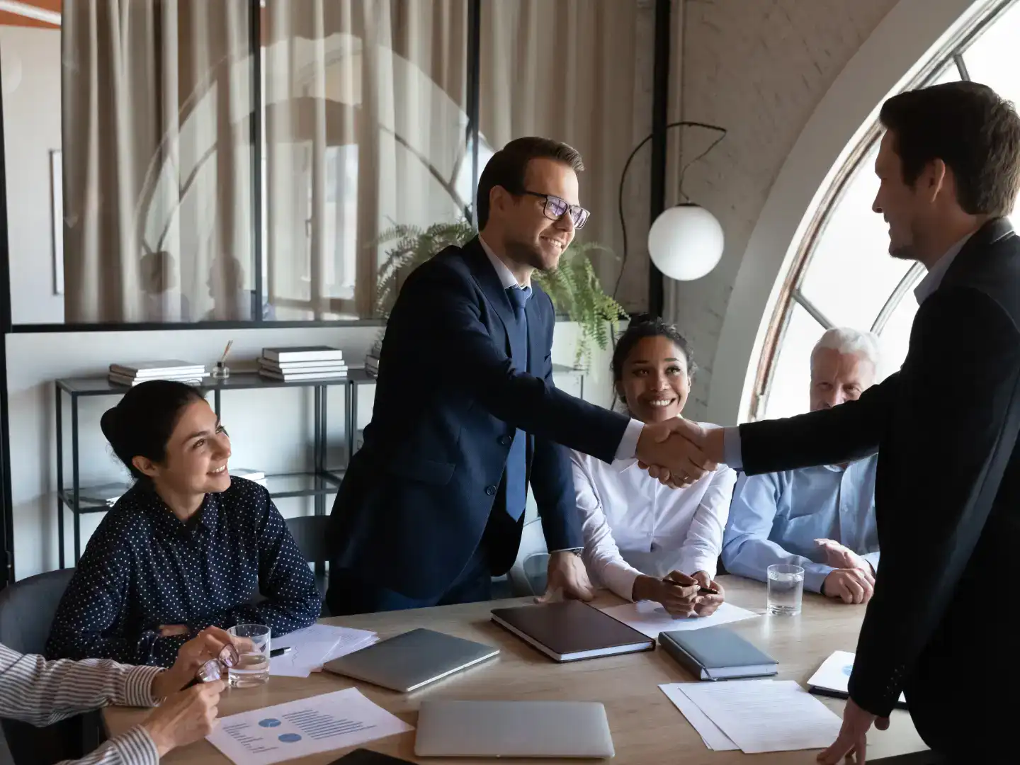 Team collaboration and handshake in a modern office setting for Lean Teams.