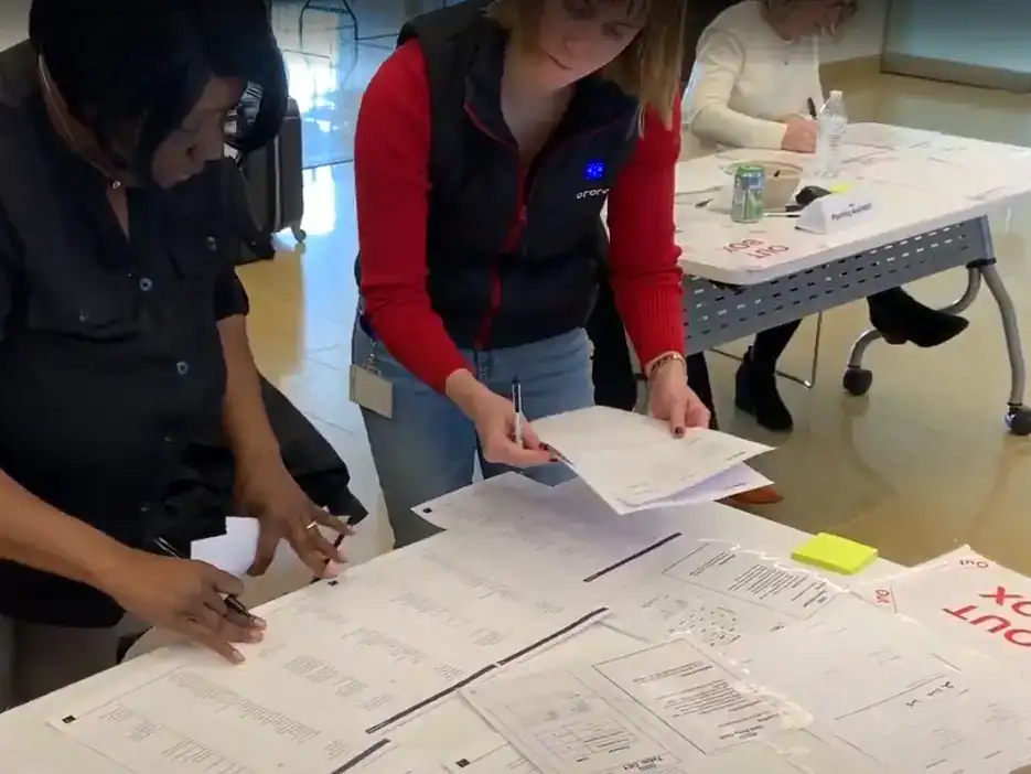 Team members collaborating on documents in a modern office setting.