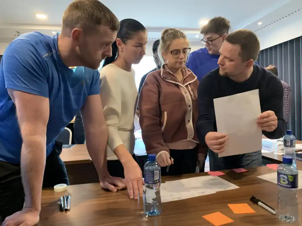 Team collaboration workshop with diverse professionals discussing strategies.