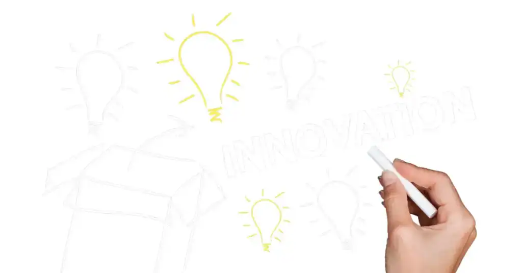 Hand drawing lightbulb ideas on a whiteboard for Lean process improvement.