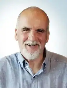 Smiling middle-aged man with a beard in a light blue shirt.